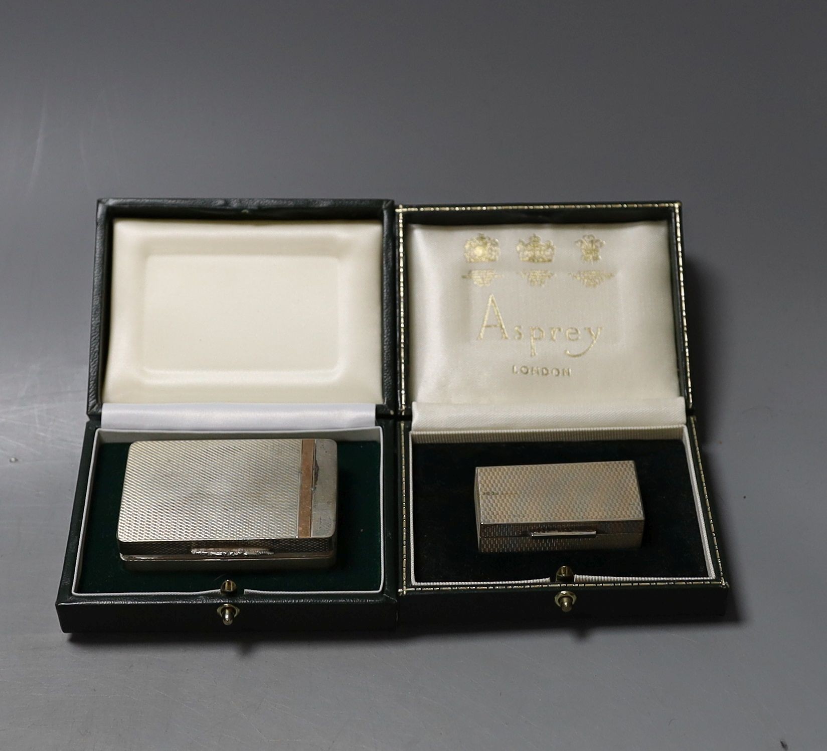 A cased modern engine turned silver pill box by Asprey & Co, Birmingham, 1965, 49mm and a later cased silver pill box by William Asprey.